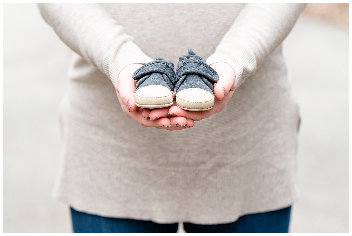 women holding little baby shoes